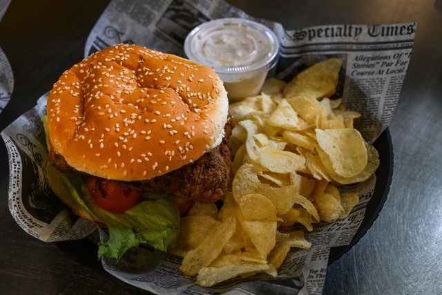 Fried chicken sandwich with chips and ranch on side